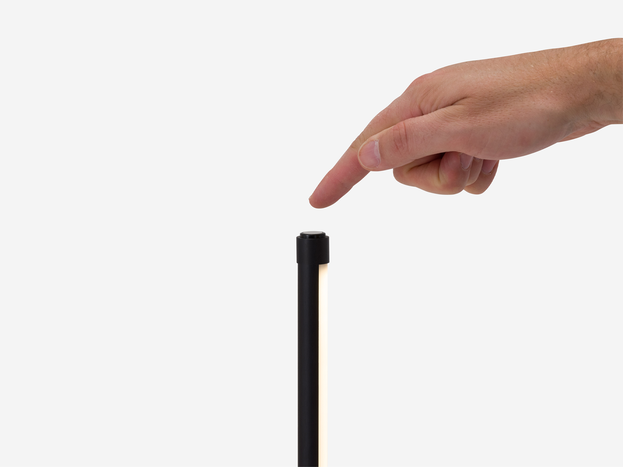 Hand turns on slim black floor lamp
